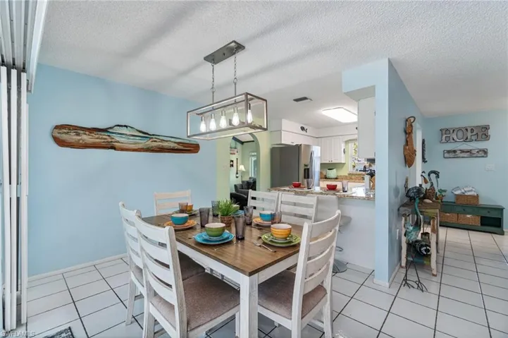 Dining area with light tile patterned floors and a textured ceiling