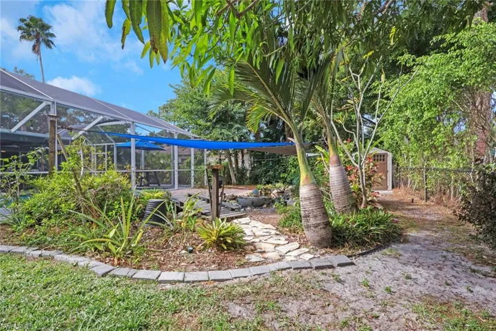 Fenced yard with glass enclosure, a storage unit, and a sunroom