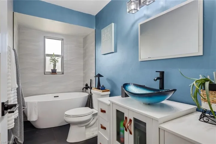 Bathroom featuring vanity, a freestanding tub, and tile patterned floors
