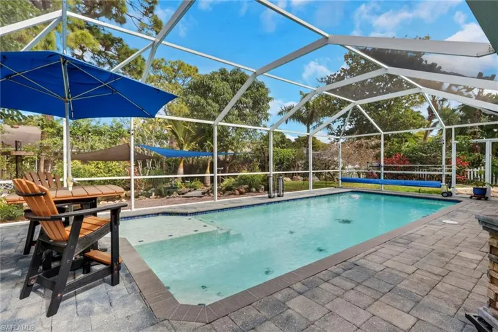 Swimming pool featuring a lanai, a patio, and a sunroom