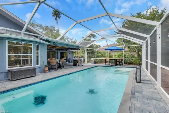 Swimming pool featuring a patio, a sunroom, a lanai, and outdoor dining space