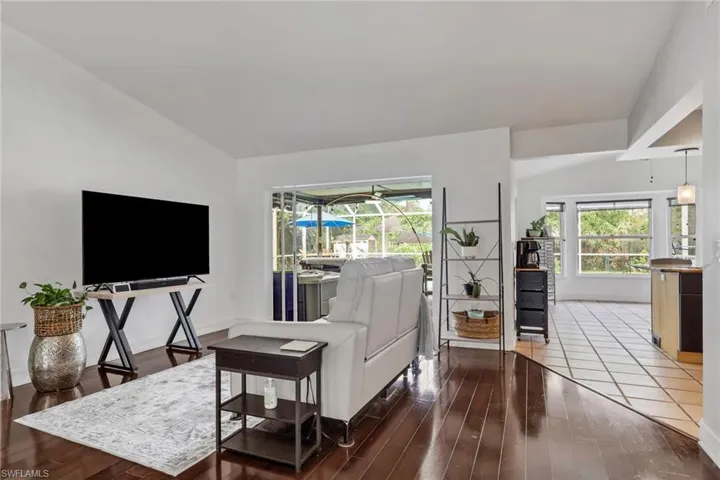 Living room featuring vaulted ceiling and dark wood-type flooring