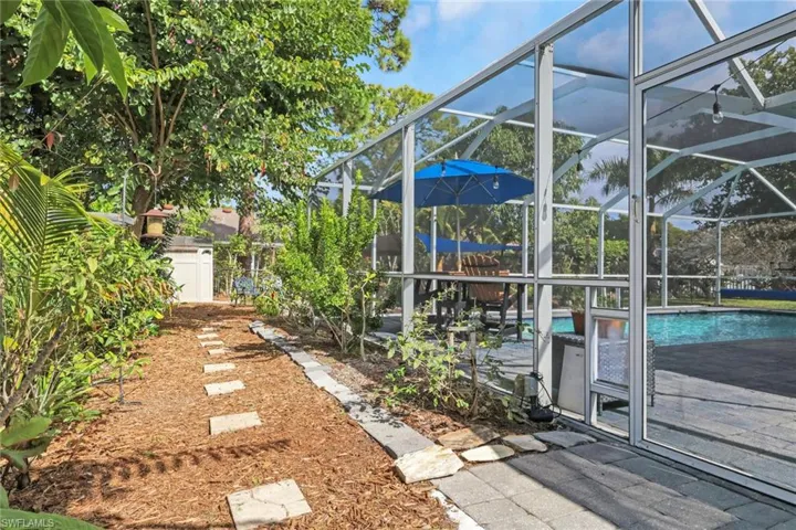 Fenced yard with a lanai, an outdoor pool, a sunroom, and a patio area