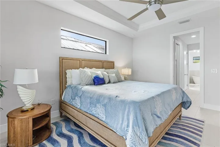 Tiled bedroom with ensuite bathroom and ceiling fan