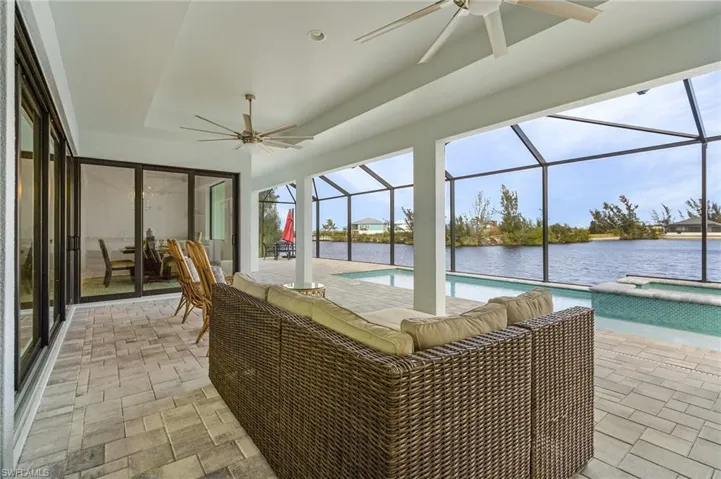 Sunroom / solarium featuring a water view, a swimming pool, and ceiling fan