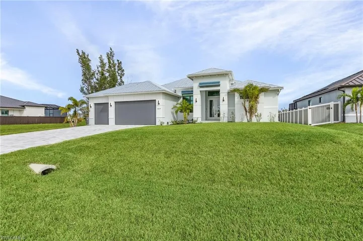 View of front facade featuring a front yard and a garage