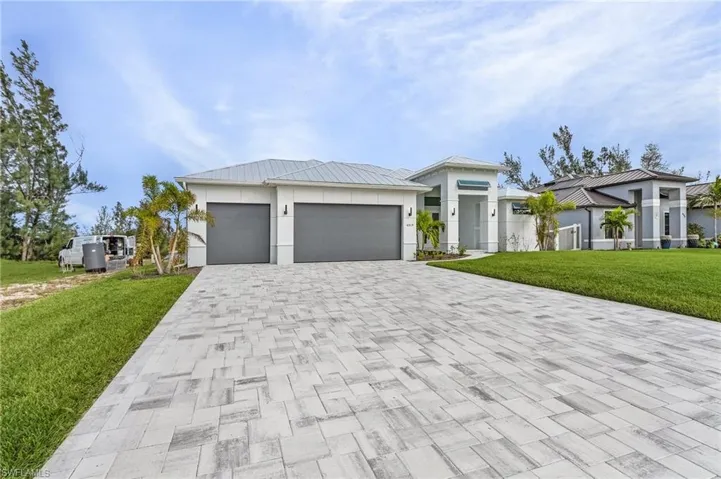 View of front facade featuring a front lawn and a garage