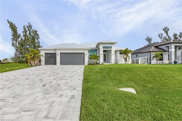 View of front of property with a front lawn and a garage