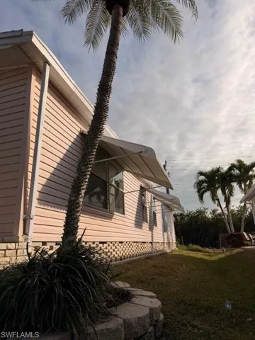 View of side of home featuring a lawn