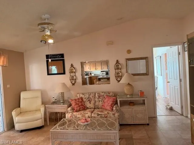 Living room featuring a ceiling fan and lofted ceiling