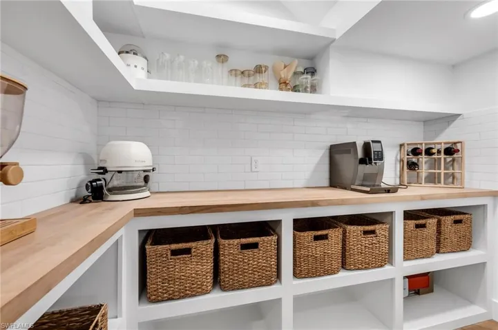 Extensive wood-finish countertops with white subway tile backsplash