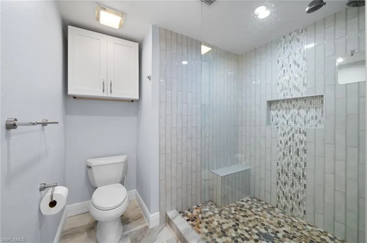 Full bathroom featuring a tile shower and toilet