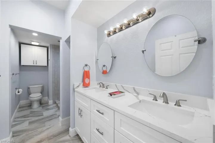 Full bath with a shower stall and double vanity