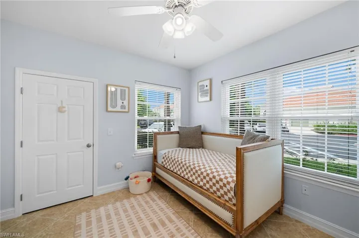 Bedroom with ceiling fan and light tile patterned flooring