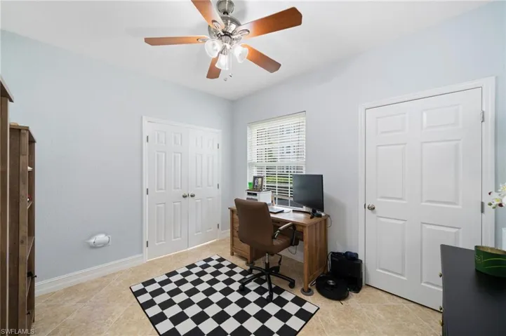 Office space featuring ceiling fan and light tile patterned flooring