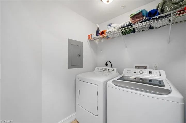 Laundry room featuring electric panel and separate washer and dryer