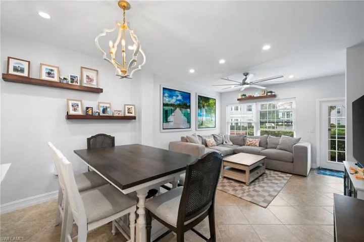 Dining space featuring a ceiling fan, light tile patterned floors, and a chandelier