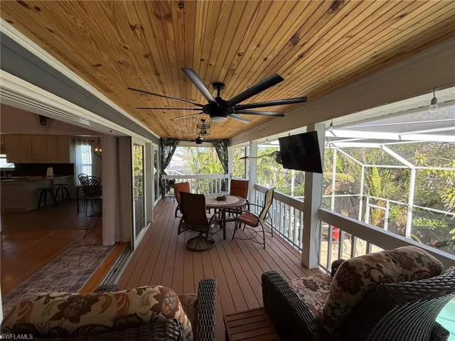 Deck featuring a ceiling fan, outdoor dining space, and a lanai