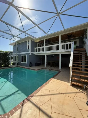 Outdoor pool featuring stairs, a lanai, a ceiling fan, and a patio area