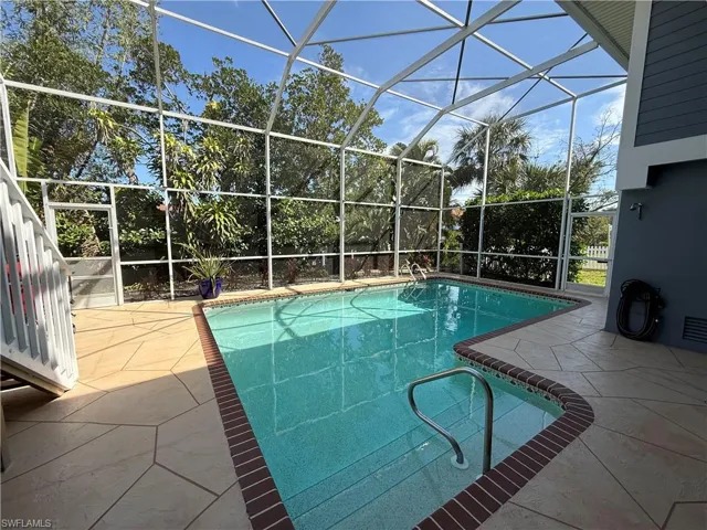 Outdoor pool featuring a patio area and glass enclosure