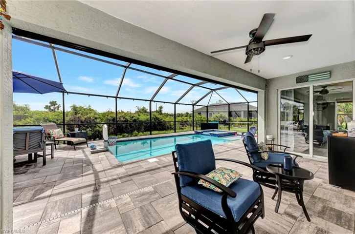 View of swimming pool featuring a lanai, a patio, an in ground hot tub, and ceiling fan