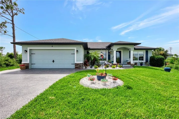 Single story home featuring a garage and a front lawn