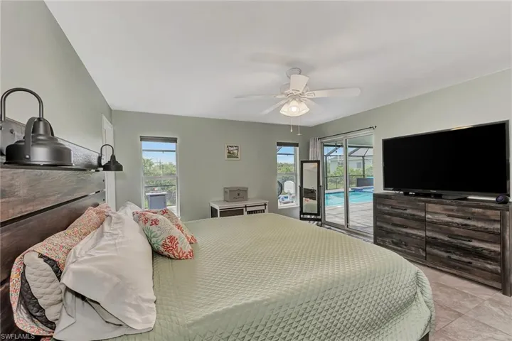 Bedroom with access to exterior, ceiling fan, and light tile patterned floors