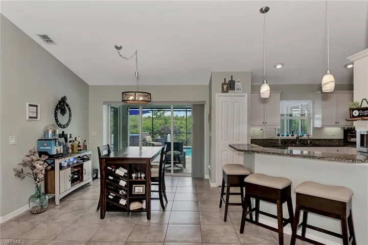 Dining room featuring light tile patterned flooring, a chandelier, and sink