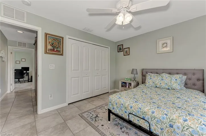 Bedroom featuring light tile patterned flooring, a closet, and ceiling fan
