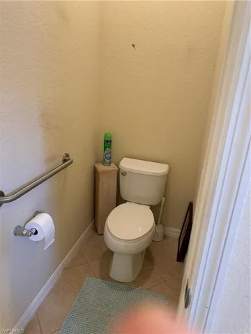 Water closet with tile flooring and toilet