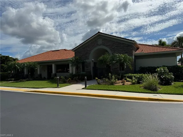 View of clubhouse property with a front lawn