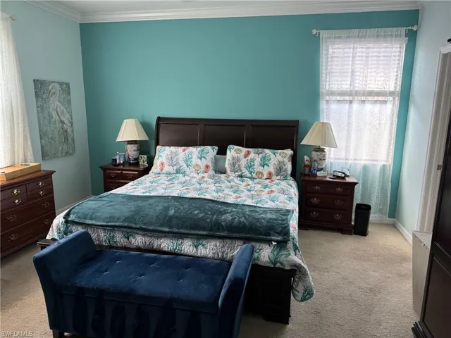 Carpeted bedroom featuring crown molding