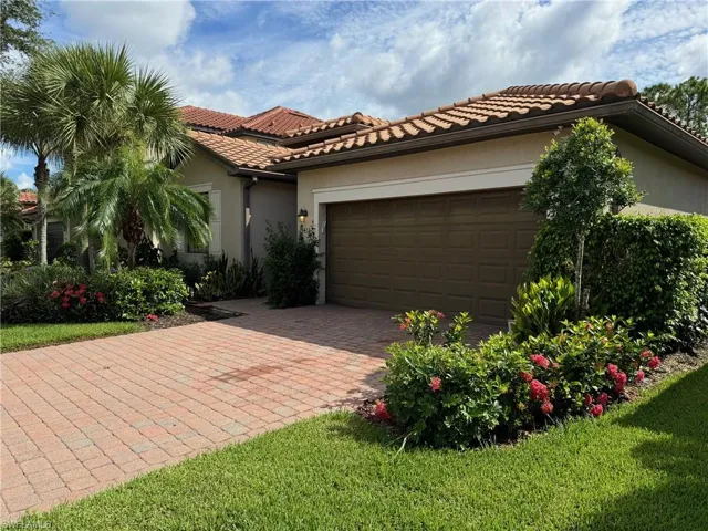 Mediterranean / spanish-style home featuring a garage and a front lawn