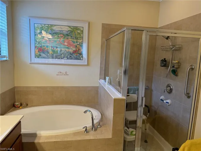 Bathroom featuring separate shower and tub and vanity