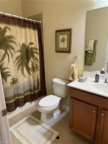 Guest Bathroom with tile flooring, vanity, and toilet