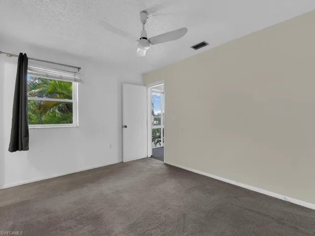 Unfurnished room with plenty of natural light, a textured ceiling, carpet floors, and ceiling fan