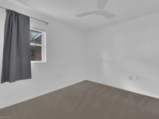 Spare room featuring carpet and a ceiling fan