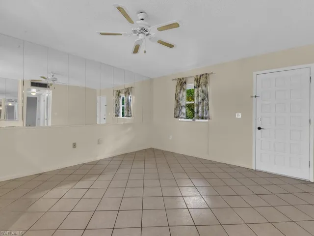 Tiled empty room featuring a ceiling fan