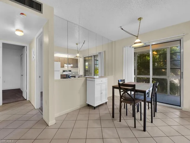Dining room with a textured ceiling and light tile patterned floors