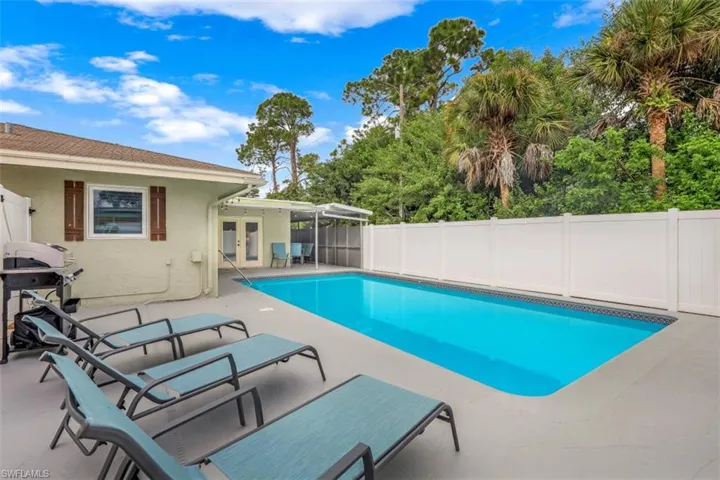 View of swimming pool with grilling area and a patio