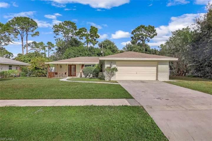 Single story home with a front lawn, a porch, and a garage