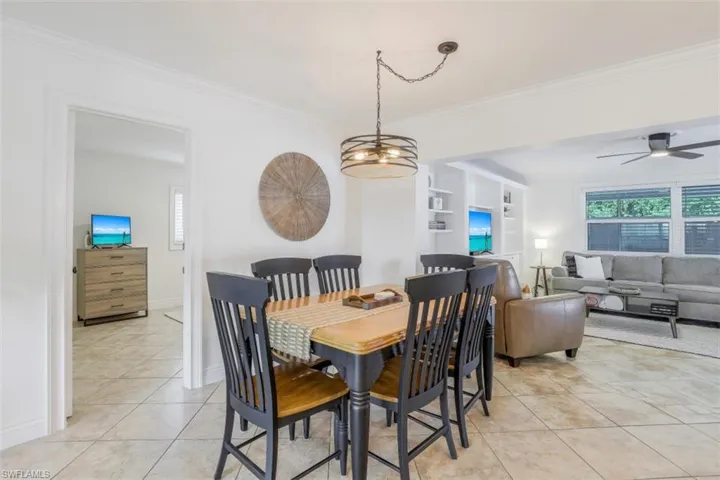 Tiled dining room with built in shelves and crown molding