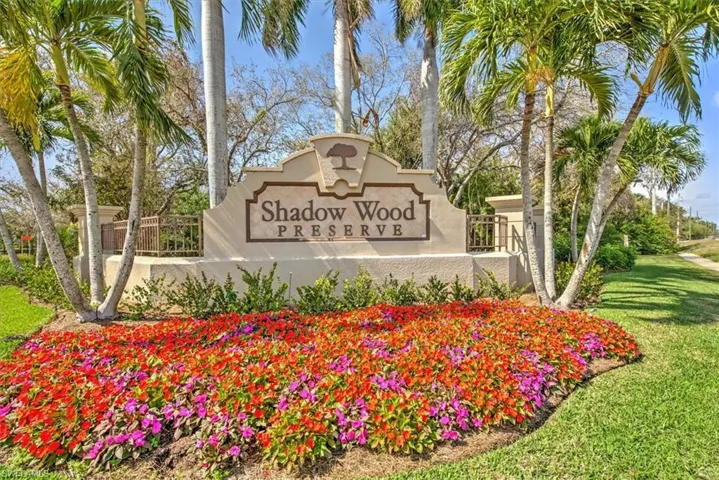 Entry monument featuring prominent lettering and a decorative tree emblem