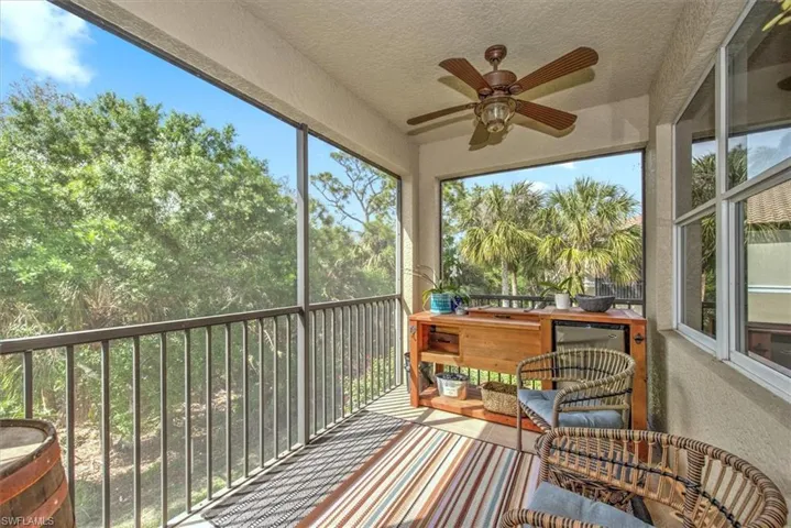 Screened balcony featuring a ceiling fan and a built-in outdoor counter with integrated storage