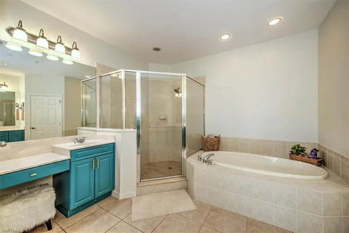 Bathroom featuring a tiled soaking tub and a glass-enclosed shower