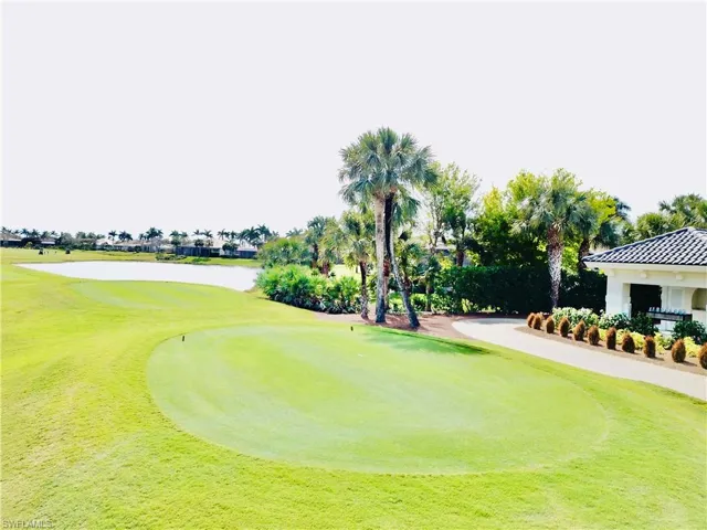 Manicured golf course green with expansive grass, bordering a large water feature