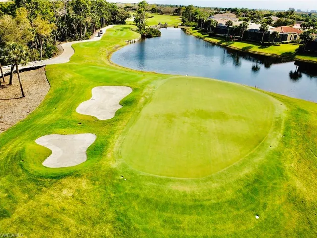 Lush golf course green with surrounding bunkers