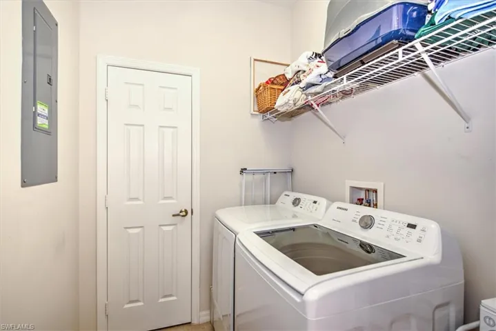 Dedicated laundry area featuring a white six-panel door, light neutral wall paint, and overhead wire shelving