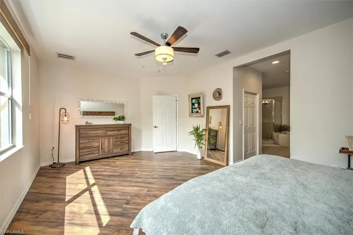 Spacious room featuring wood-finish flooring, a ceiling fan with integrated lighting, and neutral wall tones