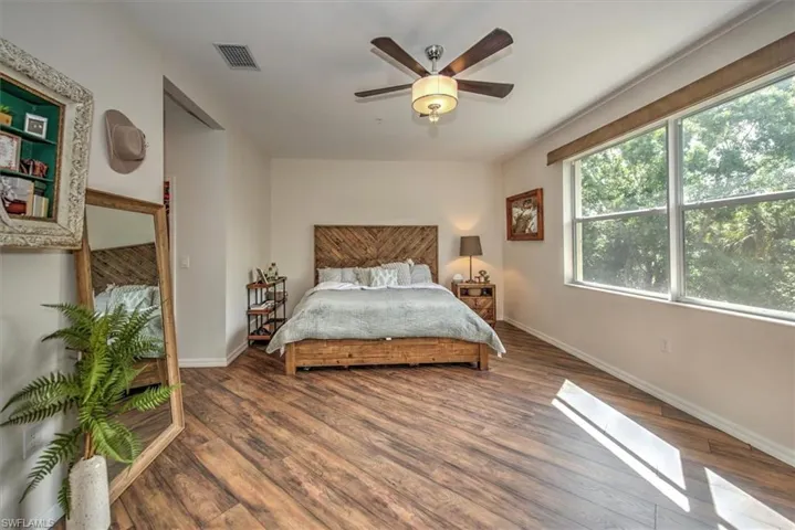 Spacious room featuring wood-finish flooring and a large window overlooking trees